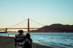 Couple walking on beach in San Francisco, California at sunset